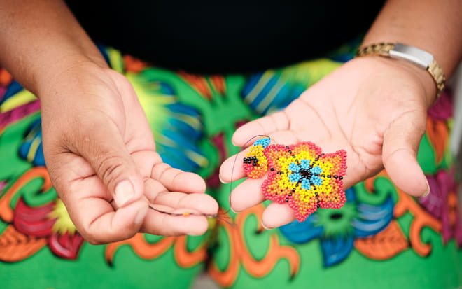 Flor de chaquiras realizada por una mujer índigena de Panamá